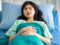 Close-up of female patient lying on hospital bed, covered with a soft blanket, sleeping tiredly after having medical treatment and Royalty Free Stock Photo