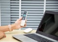 close up female person hand holding using wireless telephone calling on desk