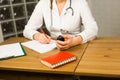 Close-up of female physician medicine doctor or pharmacist sitting at work table, holding jar or bottle of pills in hand Royalty Free Stock Photo