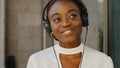 Close-up female pleased face young student teenager african american girl woman smiling wears headphones on head Royalty Free Stock Photo