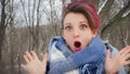 Close-up female portrait of glam rock style look of a beautiful emotional girl with dark pink hair and mohawk wearing