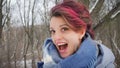 Close-up female portrait of glam rock style look of a beautiful emotional girl with dark pink hair and mohawk wearing