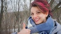 Close-up female portrait of glam rock style look of a beautiful girl with dark pink hair and mohawk wearing blue scarf