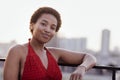 Close-up of female portrait of young adult attractive confident African. Charming darkskinned girl in red top stands against Royalty Free Stock Photo