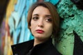 Close-up female portrait of young sad girl with short blonde hair in depression near the wall with graffiti. Youth Royalty Free Stock Photo