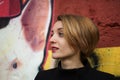 Close-up female portrait of young smiling girl with short blonde hair near the wall with graffiti. Youth culture, street Royalty Free Stock Photo