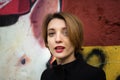 Close-up female portrait of young smiling girl with short blonde hair near the wall with graffiti. Youth culture, street Royalty Free Stock Photo