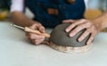 Close up female potter modeling clay bowl in workshop