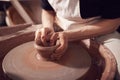 Close Up Of Female Potter Shaping Clay For Pot On Pottery Wheel In Ceramics Studio