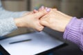 Close up of a female psychologist holding woman& x27;s hands during a therapy session.