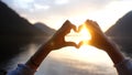 Close up on female& x27;s hands making a heart shape finger frame on lake forest landscape during sunset. People love Royalty Free Stock Photo