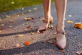 Close up of female shoes. Woman wears stylish brown high-heeled shoes in autumn park standing among falling leaves. Royalty Free Stock Photo