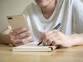 Close up female sitting at desk, holding phone in hand Royalty Free Stock Photo