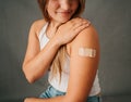 Close up female sitting and looking at the band aid on her arm Royalty Free Stock Photo