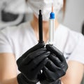 Dentist holding two syringes for gingival protection and teeth bleaching. Royalty Free Stock Photo