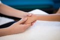 Close-up of female therapist holding hands while examining on white towel Royalty Free Stock Photo