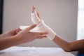 Close-up of female therapist wrapping bandage on hand