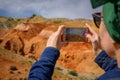 Close-up of female tourist shoots amazing natural phenomenon on her smartphone. Martian landscapes in the Altai mountains. Travel