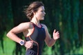 Close up of Female Triathlete running in Black Skinsuit.