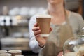 Close Up Of Female Worker in Cafe Serving Coffee In Sustainable Recyclable Cup