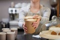 Close Up Of Female Worker in Cafe Serving Meal In Sustainable Recyclable Packaging With Wooden Spoon