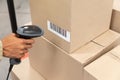 Female worker scanning package with barcode scanner in warehouse