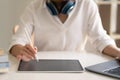 Close up of female worker working from home with digital tablet, laptop and headphone in home office room. Royalty Free Stock Photo