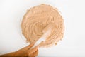 Close-up of female wrinkled hand ofcook decorating cake with cream filling using spatula