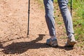 Close-up of feminine feet hiking on the trail with hiking poles