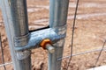 A close-up of a metal fence with a bolt attached to its top.