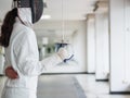 Close-up of a fencer in white fencing suit and holding a sword o