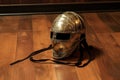 a close-up of a fencing mask and foil on a wooden floor