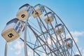 Close up ferris wheel against blue cloudy sky