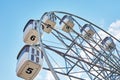 Close up ferris wheel against blue cloudy sky