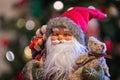 Close up of a festive Father Christmas Doll with Christmas tree and lights Royalty Free Stock Photo
