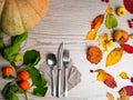 festive thanksgiving autumn cutlery setting and arrangement of colorful fall leaves, red berries, pumpkin Royalty Free Stock Photo