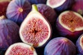 Close-up of figs on wooden table. Fresh slice of fig lying on a heap of ripe figs. Heap of tasty organic figs. Ripe exotic fruit. Royalty Free Stock Photo