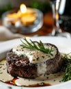 close-up of a filet mignon with white cream topped with rosemary