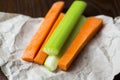 Close up filled frame shot of party snack food. A bunch of crunchy orange carrot and juicy green celery sticks laying on a piece Royalty Free Stock Photo