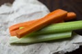 Close up filled frame shot of party snack food. A bunch of crunchy orange carrot and juicy green celery sticks laying on a piece Royalty Free Stock Photo