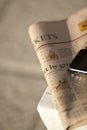 Close-up of financial newspaper and mobile phone
