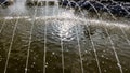 Close-up of fine jets of water coming out of a fountain into a pond with clean water