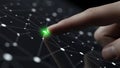 Close-up of a finger activating a glowing green connection point in a digital network Royalty Free Stock Photo