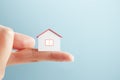 Close up of finger holding tiny house on background with mock up place for advert. Loan and insurance concept Royalty Free Stock Photo