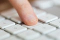 Close up of finger pressing button on keyboard