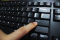 Close Up of Finger Pressing Enter Key on Black Computer Keyboard Royalty Free Stock Photo