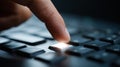 Close-up of a finger pressing a glowing key on a black computer keyboard with shallow depth of field and dark background Royalty Free Stock Photo