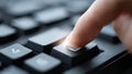 Close-up of finger pressing a key on a black computer keyboard with soft focus and light flare effect Royalty Free Stock Photo