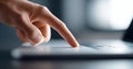 Close-up of a finger pressing a laptop touchpad with blurred background and soft lighting in a modern workspace Royalty Free Stock Photo