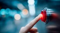 Close-up finger pressing a red emergency stop button on an industrial control panel with blue bokeh lights Royalty Free Stock Photo